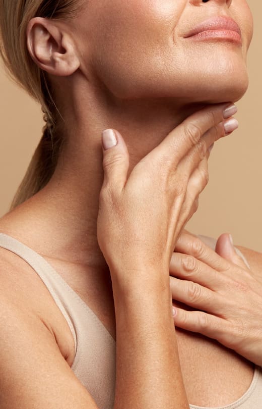 A woman feeling her neck after skin treatment at The Day Clinic